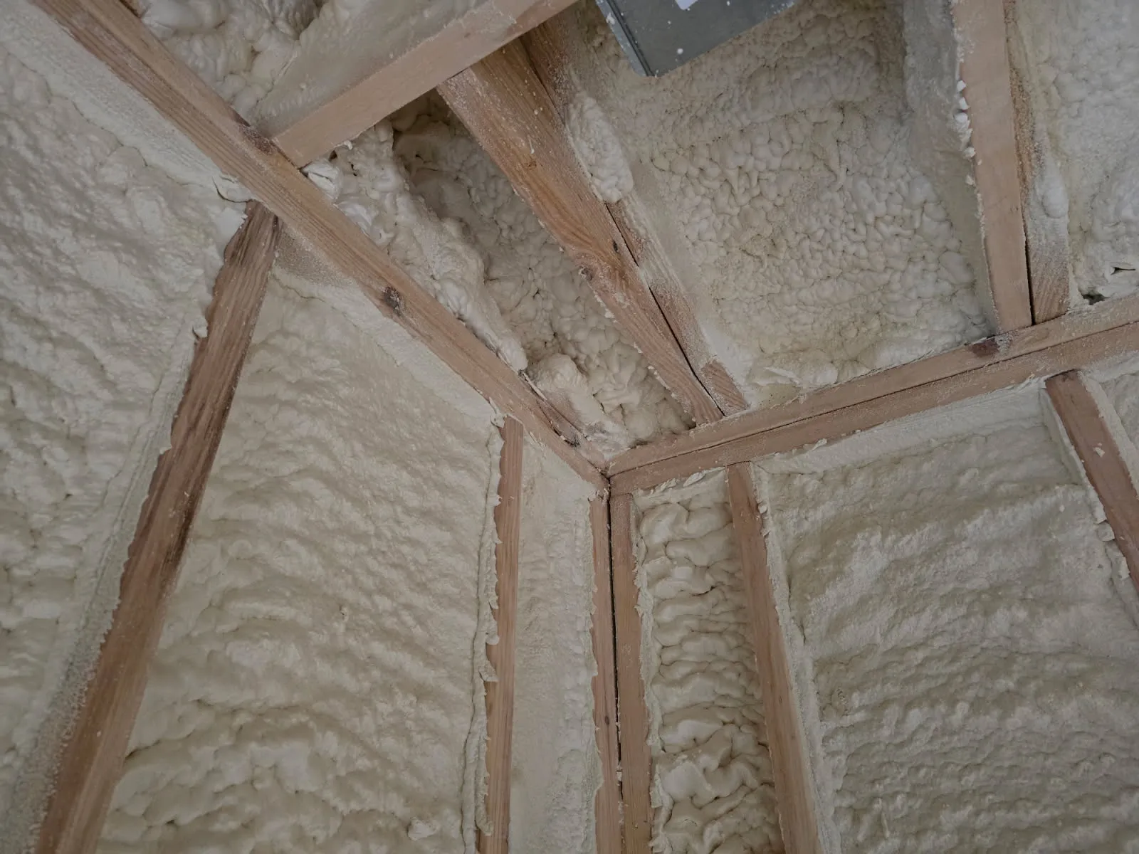 Close-up of spray foam at wall-ceiling corner junction