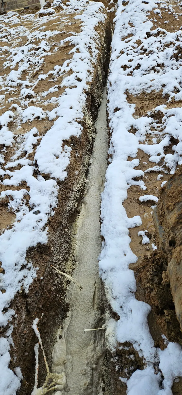 Foundation footing trench with spray foam in winter