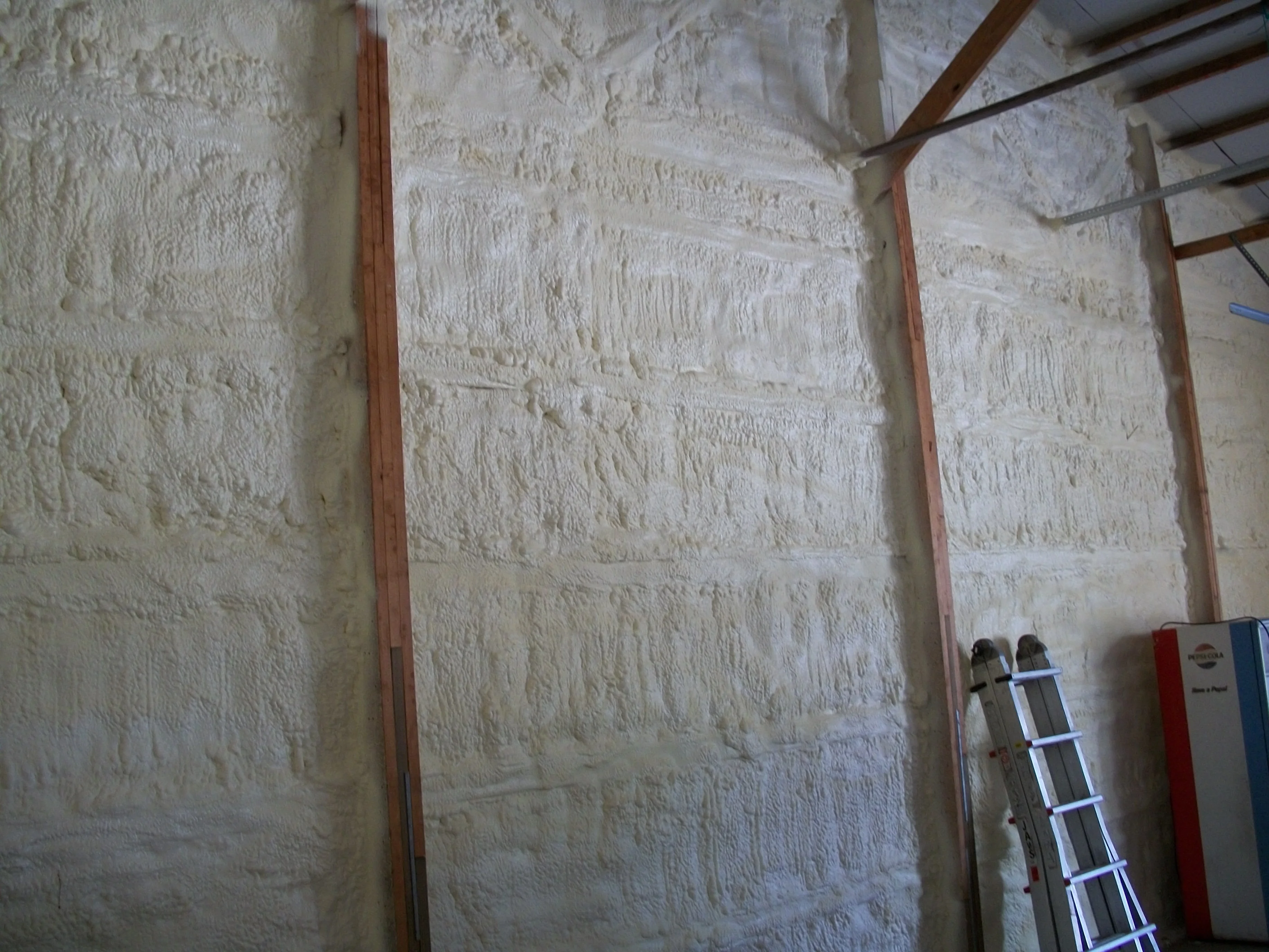 Pole barn wall with closed-cell spray foam